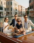 Group of four people on a boat in a canal with Venetian architecture.

